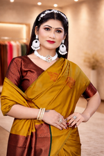 Close-up of a mustard yellow silk saree featuring copper leaf motifs paired with a matching rich copper brocade blouse.