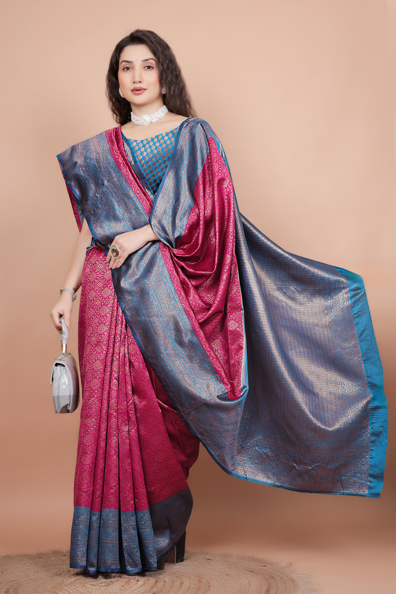 Posed shot of a woman in a rani pink traditional silk saree holding a stylish bag