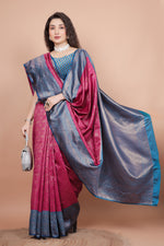 Posed shot of a woman in a rani pink traditional silk saree holding a stylish bag