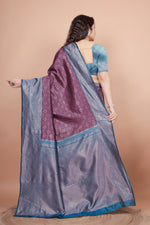 Back view highlighting the textured peacock blue blouse and the flowing woven zari pallu